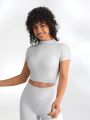SHEIN Leisure Front View Of Model Posing In The Fitted Cropped Pearl Grey Rib Contrast Stitch Crop Tee With Stitched Seaming, Cap Sleeves And A Mini Mock Neckline Close Up Detail Front View Of Model Posing In The Fitted Cropped Pearl Grey Rib