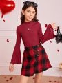 SHEIN Kids FANZEY Girls' Knit Solid Color Stand Collar Top And Knit Plaid Skirt Set